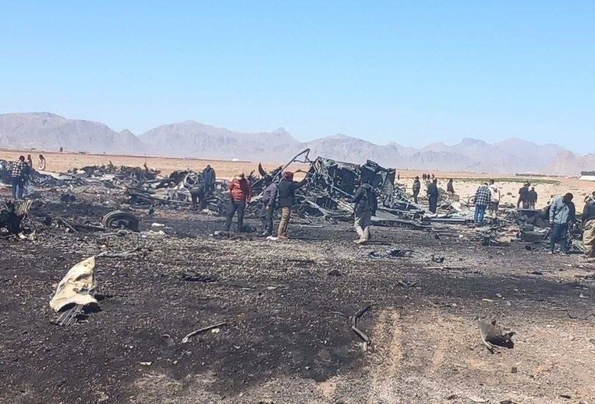 אירנים סקרנים בוחנים את שברי המטוסים האמריקניים.